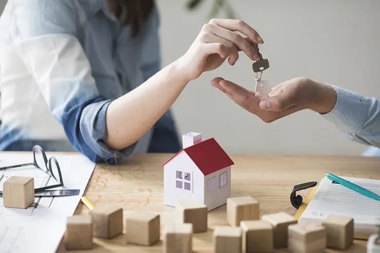 woman handing man keys to new home